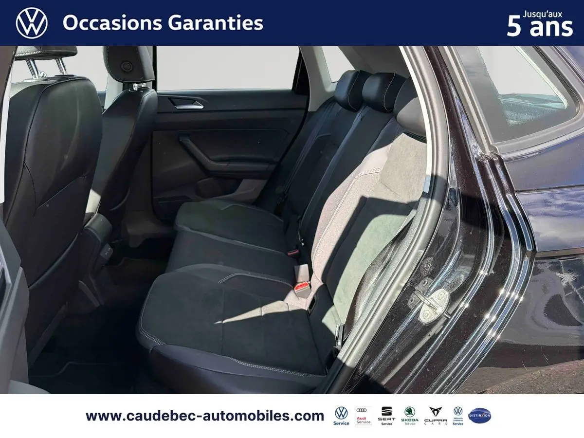 Vue côté droit sur l'intérieur arrière d'une Volkswagen Polo noire intense nacrée avec sièges tissu et alcantara.