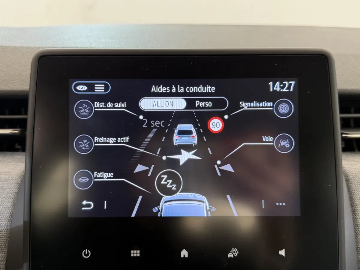 Écran tactile central de la Renault Clio 2025 affichant les aides à la conduite avec alertes et vitesses.