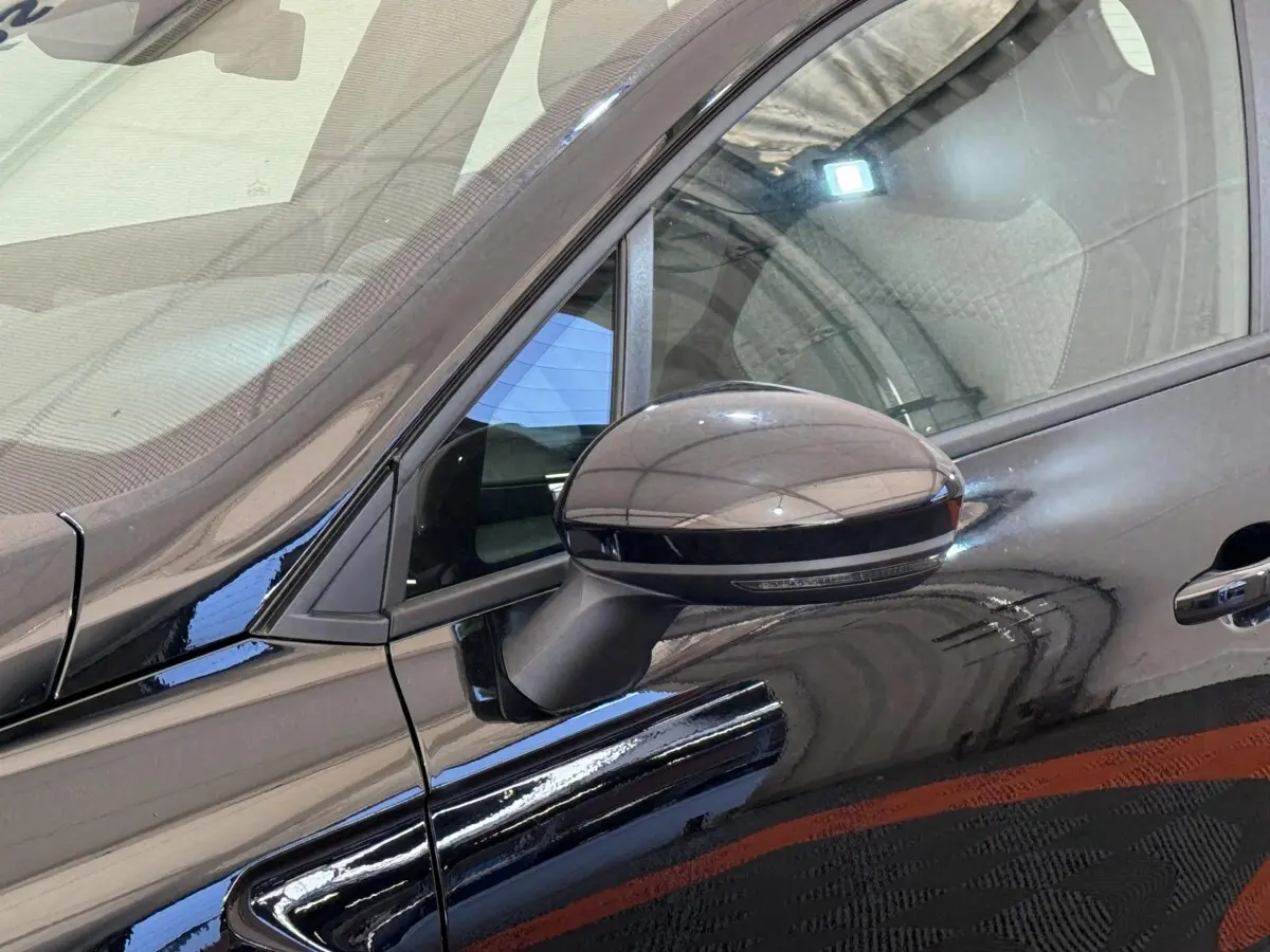Rétroviseur côté gauche noir brillant de la Renault Clio Evolution Blue dCi 100 -25, vue rapprochée sur porte avant.