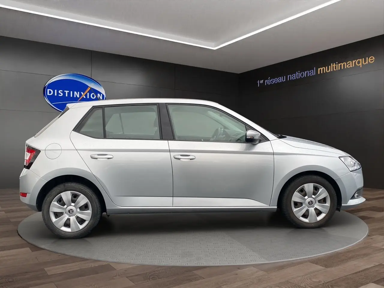 Vue de profil côté droit d'une Skoda Fabia gris argent 2021 avec jantes acier et finition Ambiente en showroom.