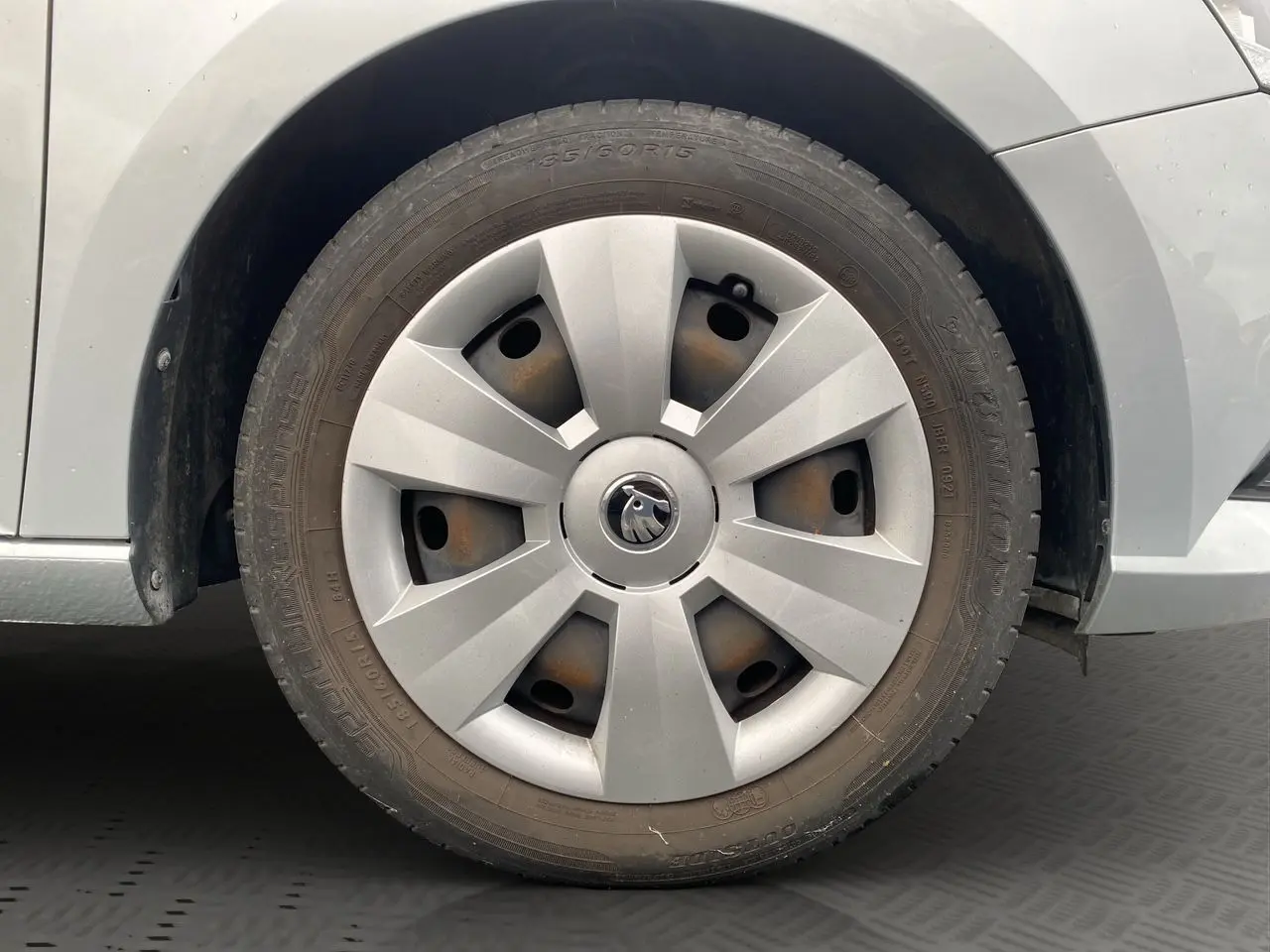 Gros plan sur la roue avant droite gris argent d'une Skoda Fabia 2021 avec enjoliveur et logo central visible.