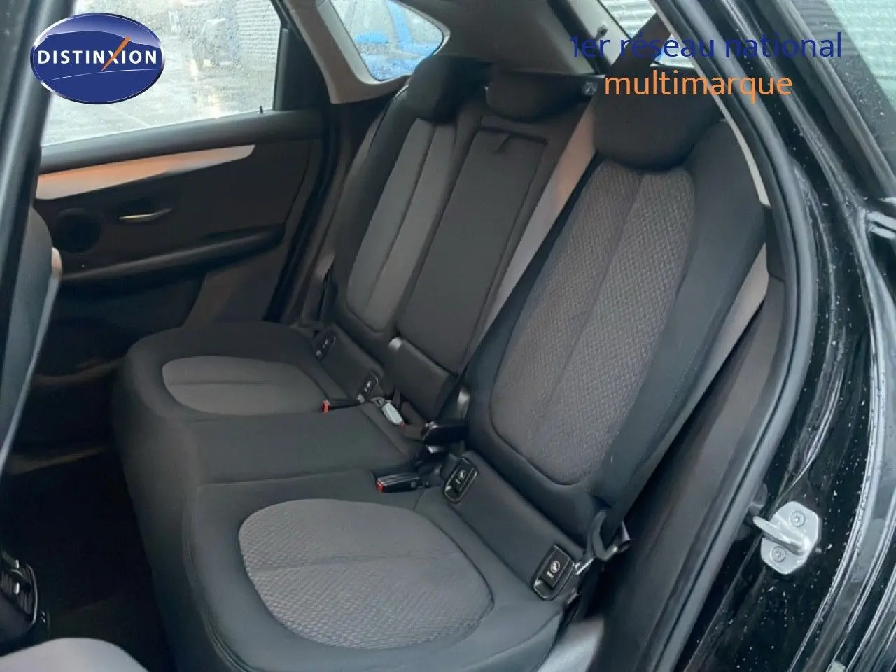 Vue intérieure côté droit montrant la banquette arrière en tissu gris et noir du BMW Série 2 Active Tourer noir saphir métal.