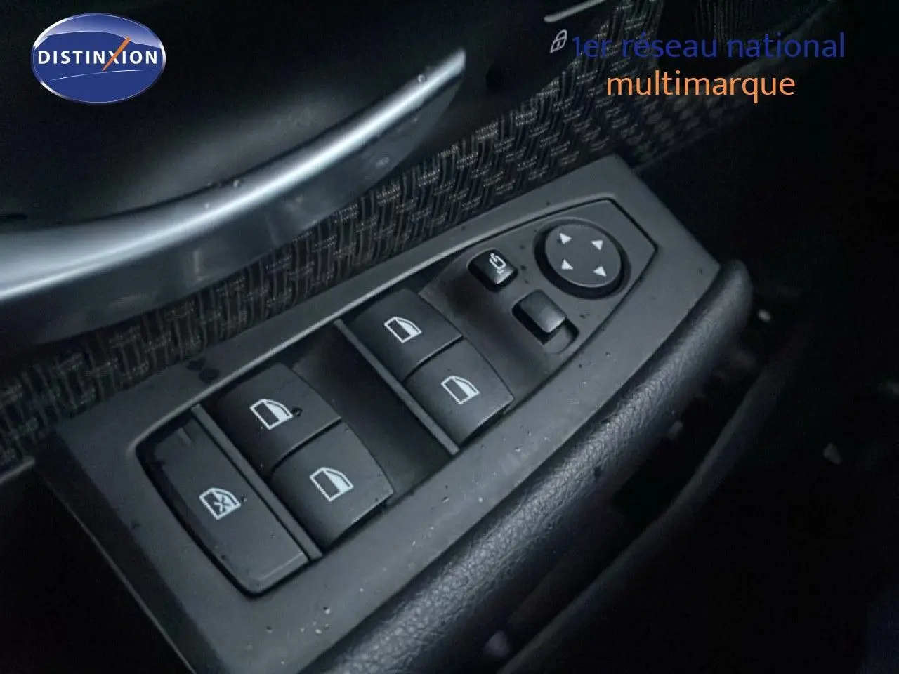 Gros plan sur les commandes des vitres électriques côté gauche d’une BMW Série 2 Active Tourer noire, intérieur tissu noir.