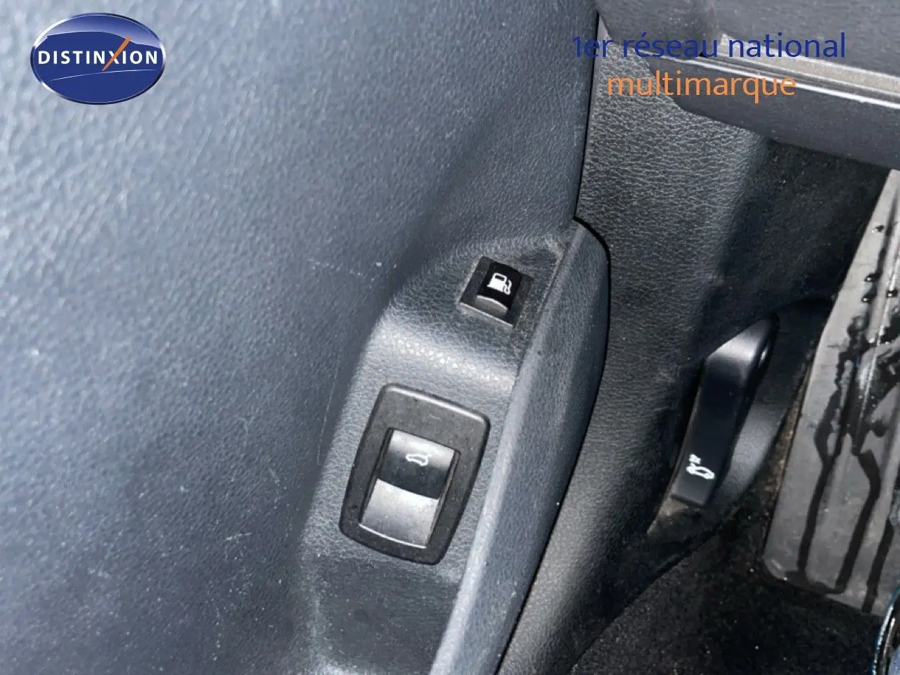 Gros plan sur les commandes d’ouverture du capot et de la trappe à carburant dans l’habitacle noir d’une BMW Série 2 Active Tourer 225XE.