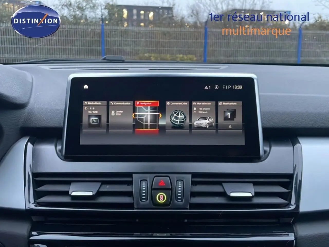 Vue intérieure du tableau de bord de la BMW Série 2 Active Tourer 225XE, écran central affichant la navigation et les options connectées.