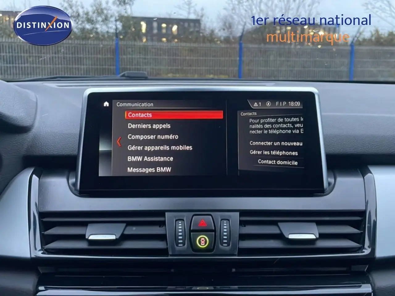 Vue intérieure du tableau de bord de la BMW Série 2 Active Tourer noire, avec écran central affichant le menu communication.