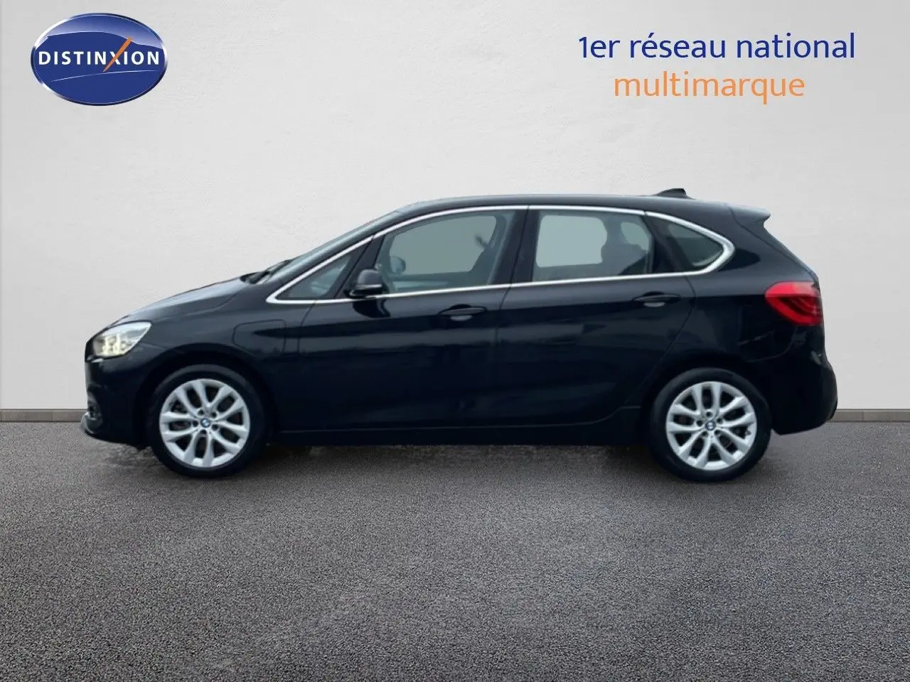 Profil latéral droit d'une BMW Série 2 Active Tourer noire Saphir Métal, avec jantes alliage et lignes fluides.