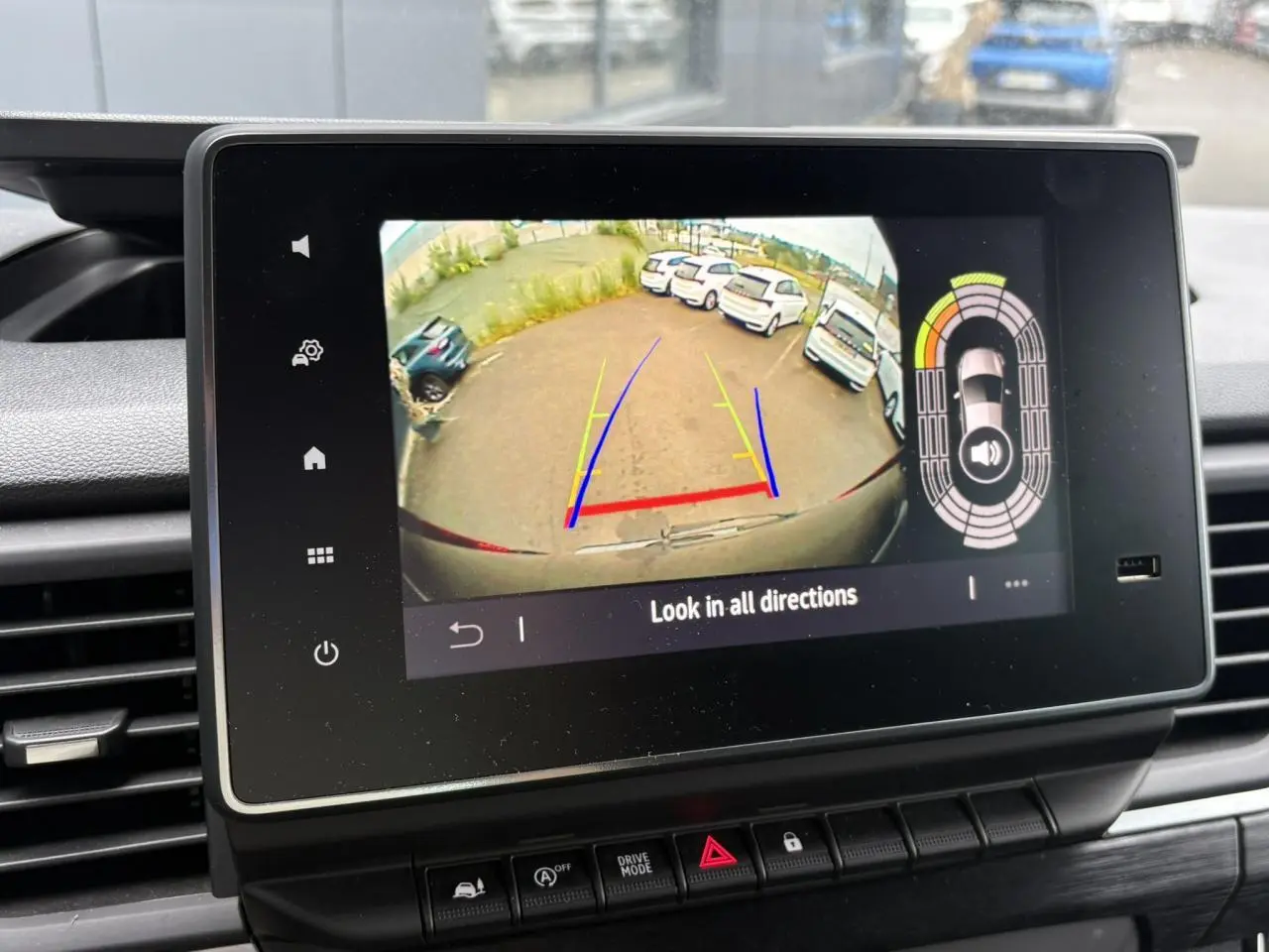 Écran tactile intérieur montrant la caméra de recul du Nissan Primastar gris Comète, avec guidage de trajectoire coloré.