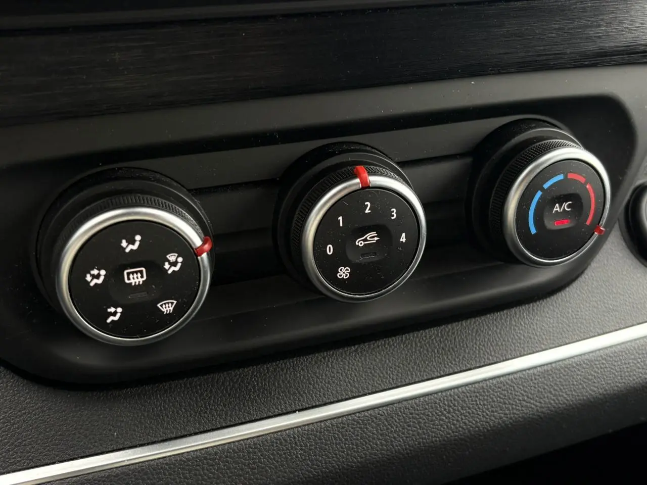 Gros plan sur les commandes de climatisation du Nissan Primastar gris, avec réglages de ventilation, vitesse et température.