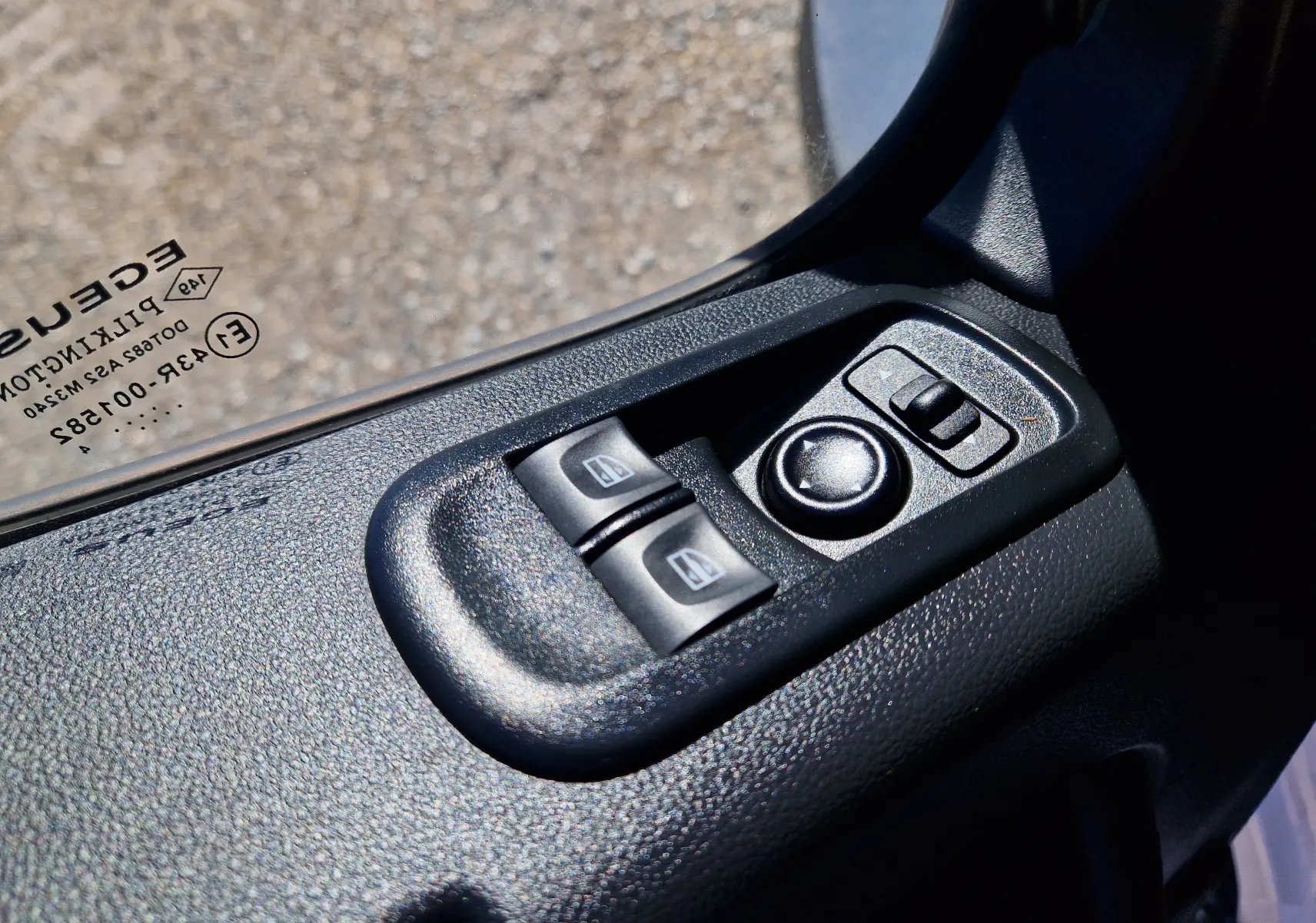 Gros plan sur les commandes électriques des vitres et rétroviseurs côté conducteur d’un Renault Master blanc 2024.