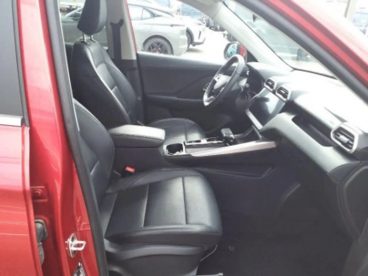 Vue intérieure côté conducteur du MG ZS 1.5 Hybrid+ 197 Luxury rouge Diamond, sièges noirs et tableau de bord moderne.