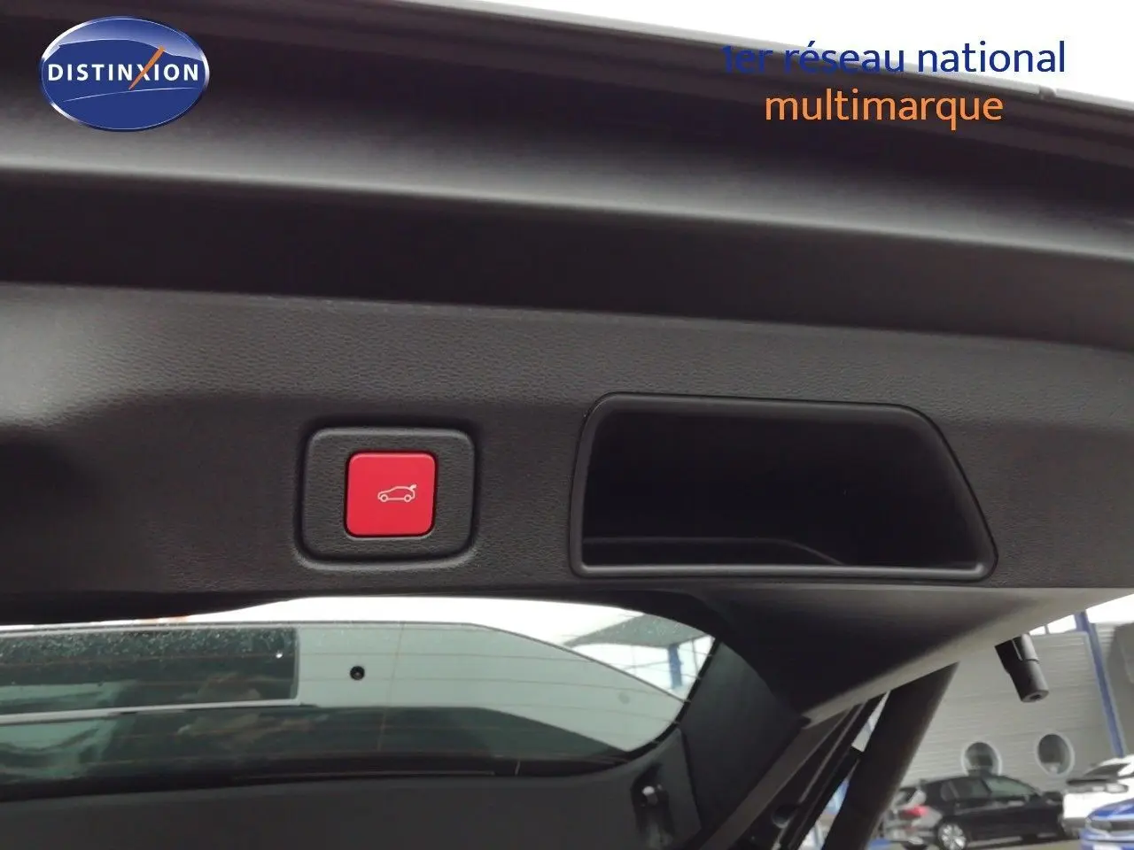 Bouton rouge d'ouverture électrique du coffre visible sur la partie intérieure du hayon d'un Jeep Compass noir Vulcano métal.
