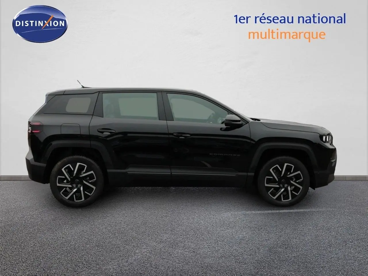 Vue de profil côté gauche d'un Jeep Compass noir Vulcano métal avec jantes distinctives et lignes anguleuses modernes.