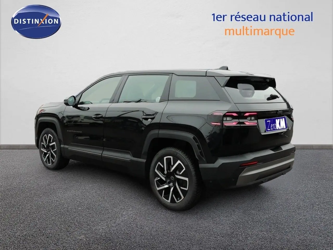 Jeep Compass noir Vulcano métal en 3/4 arrière droit, avec jantes alliage distinctives et feux arrière LED allumés.