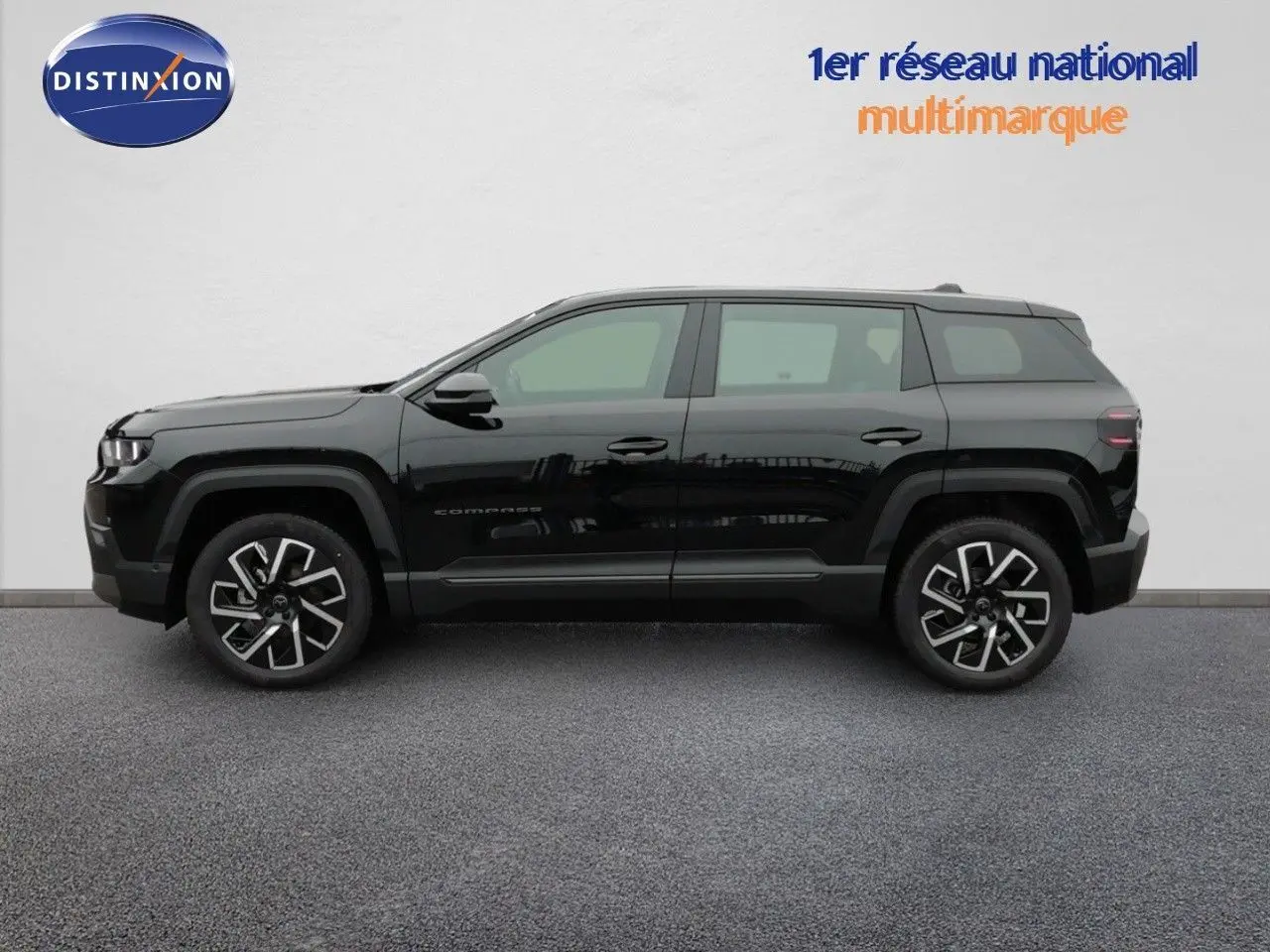 Vue de profil côté gauche d'un Jeep Compass noir Vulcano métallisé, soulignant ses jantes alliage et sa silhouette compacte.