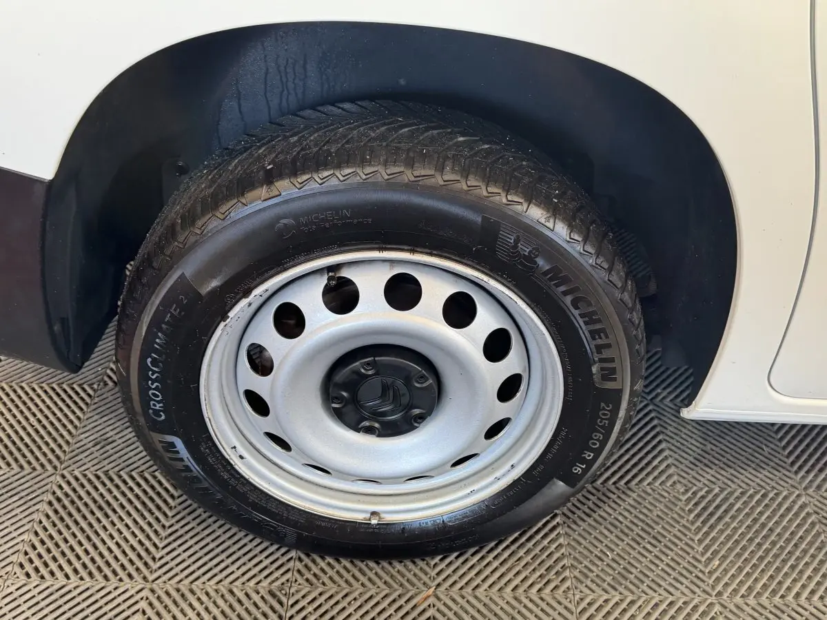 Gros plan sur la roue avant droite en jante acier du Citroën Berlingo blanc de 2020.