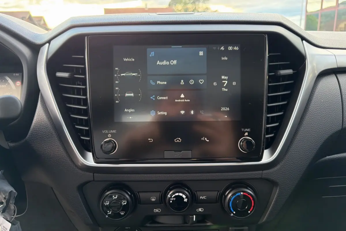 Vue rapprochée de l’écran tactile central du tableau de bord de l’Isuzu D-MAX 2026 avec commandes climatisation.