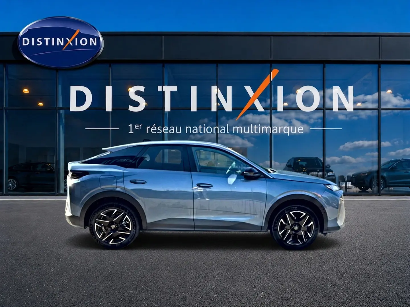 Profil droit d'un Peugeot 3008 bleu 2025 garé devant une vitrine avec logo Distinxion, jantes alu visibles.