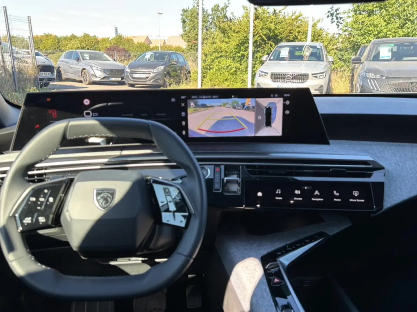 Vue intérieure du tableau de bord de la Peugeot 3008 bleu, avec volant multifonction et écran tactile affichant la caméra de recul.