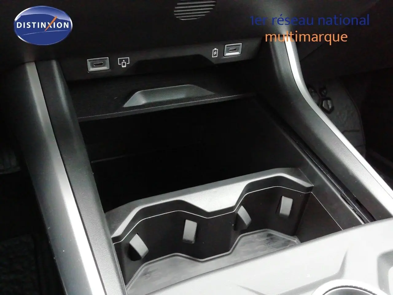 Gros plan sur la console centrale du Jeep Compass 2026 noir Vulcano, montrant les porte-gobelets et ports USB.