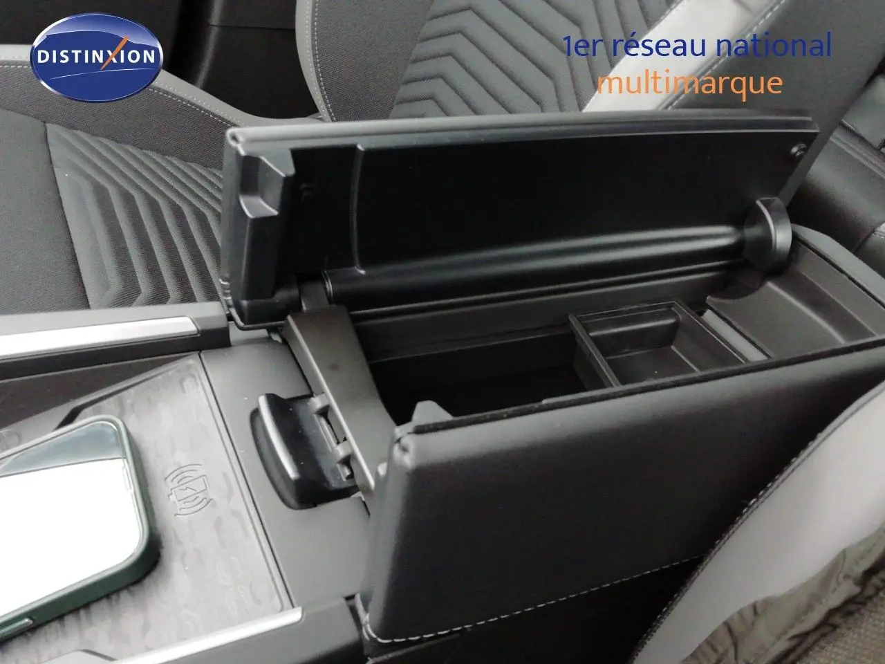 Intérieur du Jeep Compass MHEV 145ch en noir, vue rapprochée sur l'accoudoir central ouvert avec rangement et console tactile.