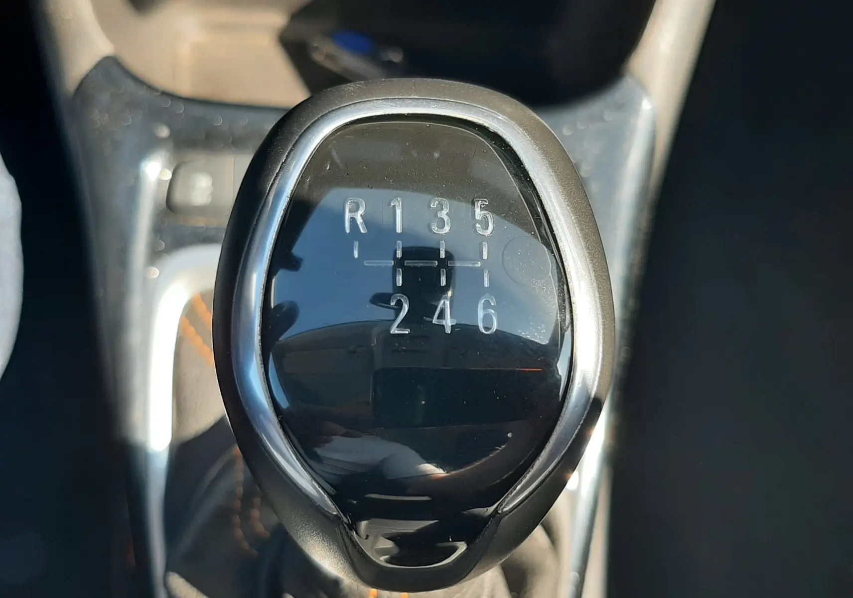 Le levier de vitesses manuel noir brillant de l'Opel Crossland X 130ch Innovation, avec marquages des six rapports et de la marche arrière.