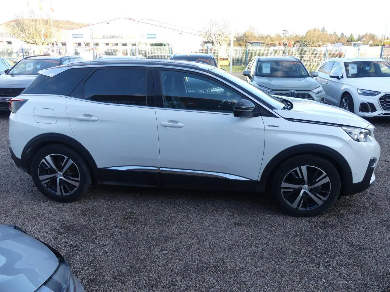 Profil côté gauche d'un Peugeot 3008 blanc nacré 2020 avec toit noir et jantes alliage bicolores.