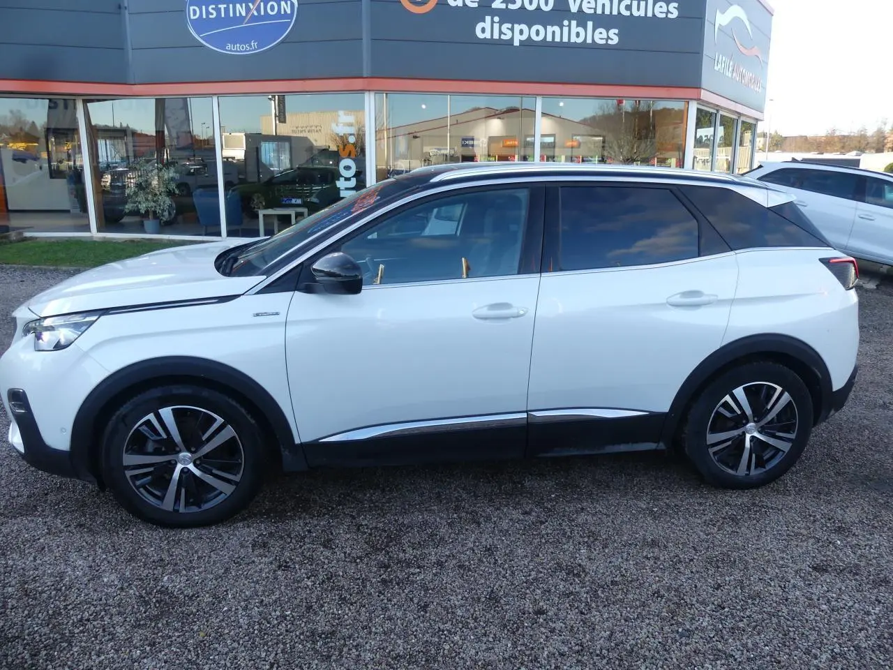 Profil côté gauche d'un Peugeot 3008 GT Line blanc nacré avec toit noir et jantes alliage bi-ton.