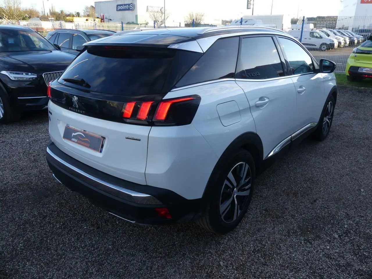 Peugeot 3008 GT Line blanc nacré vue 3/4 arrière droit avec toit noir et feux arrière LED distinctifs.