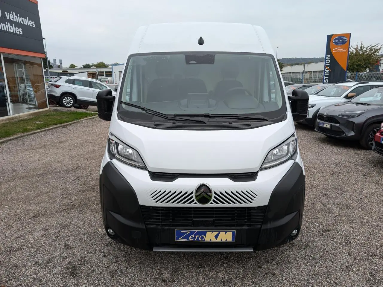 Vue de face d'un utilitaire blanc Citroën Jumper 2025 avec pare-chocs noir et logo Citroën distinctif au centre.
