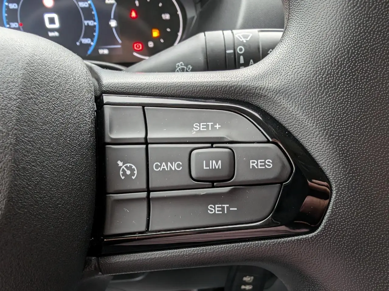 Gros plan sur les commandes du régulateur de vitesse au volant du Citroën Jumper 2025, finition noire.