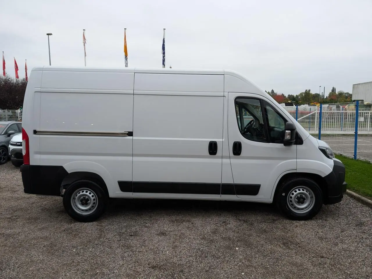 Profil latéral droit d'un utilitaire Citroën Jumper blanc avec porte coulissante et roues acier 16 pouces.