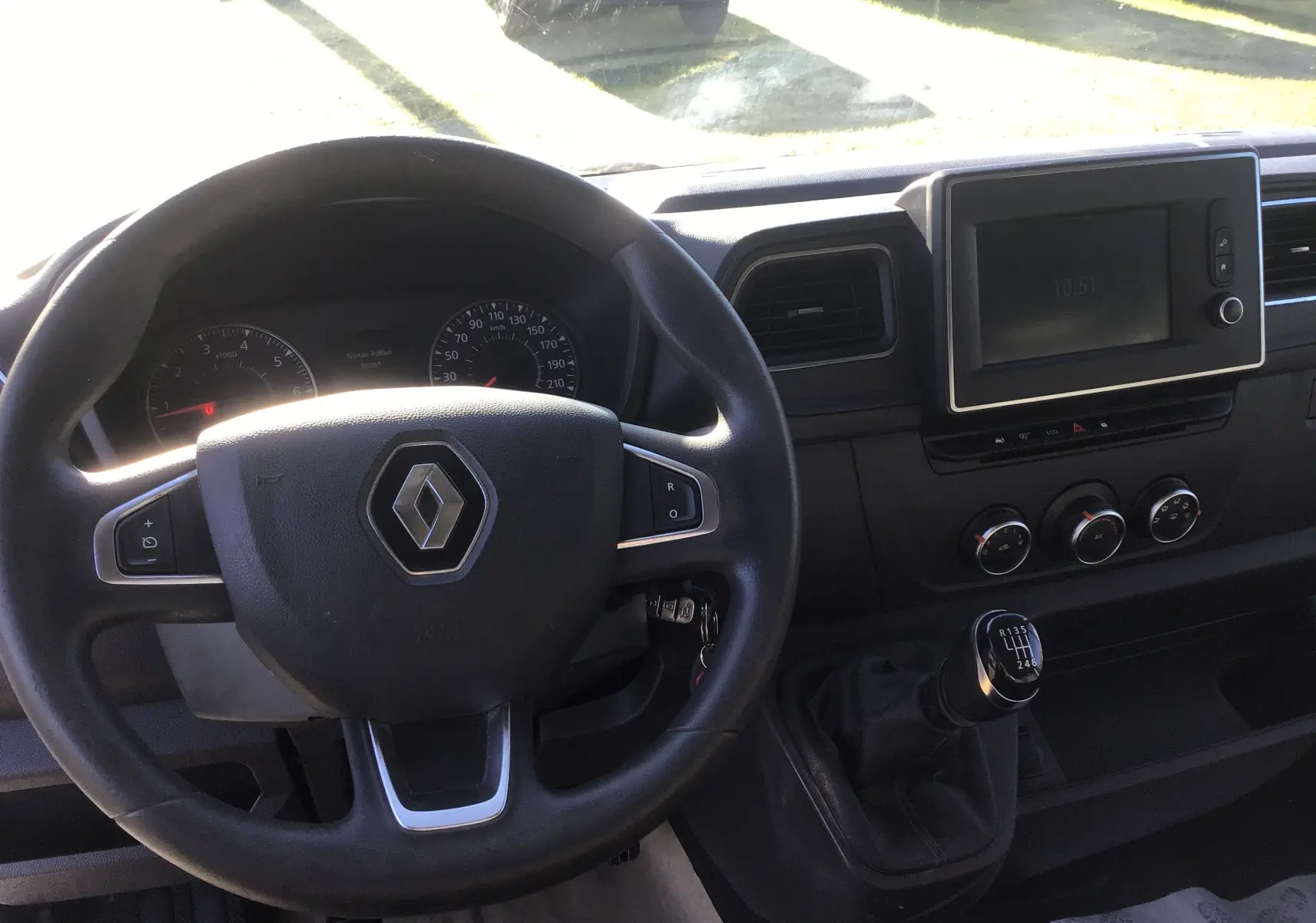 Vue intérieure du tableau de bord du Renault Master blanc 2020, avec volant, écran tactile et levier de vitesses manuel visible.