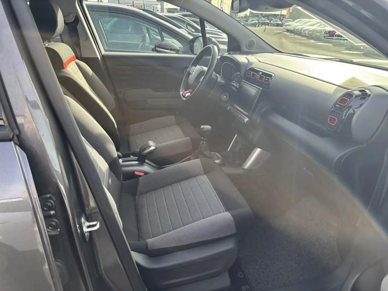 Vue intérieure arrière côté droit de la banquette arrière noire et grise avec bande rouge de la Citroën C3 Aircross 2021.