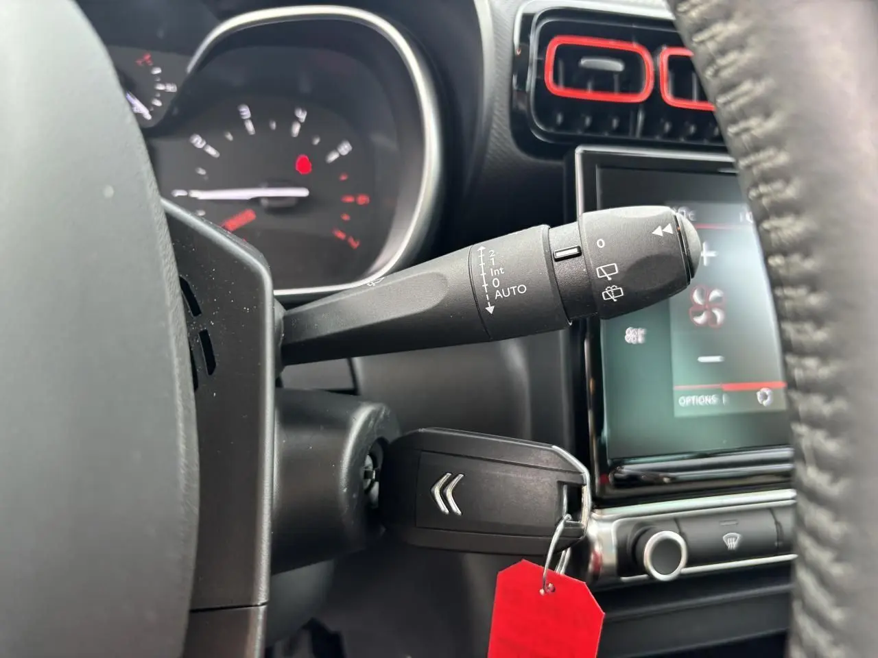 Gros plan sur la commande d’essuie-glace et clé de contact dans l’habitacle noir du Citroën C3 Aircross 2021.