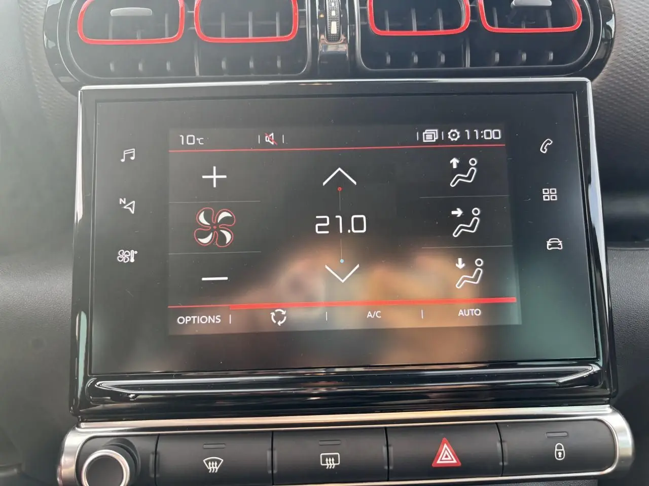 Écran tactile central de la Citroën C3 Aircross 2021 affichant la climatisation à 21°C avec cadre noir brillant et aérateurs rouges.