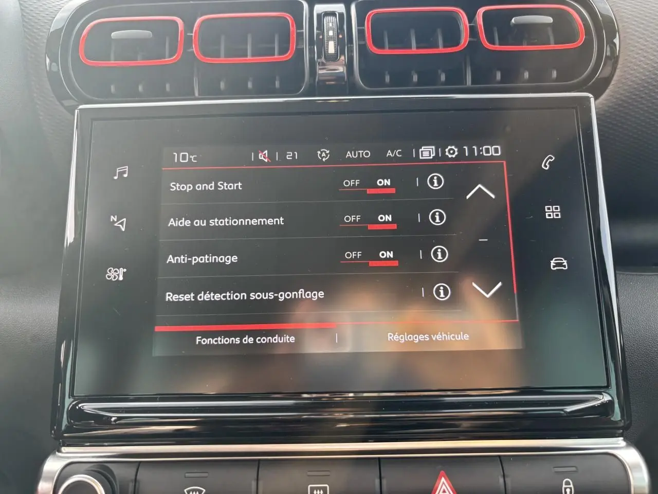 Vue rapprochée de l'écran tactile central du tableau de bord du Citroën C3 Aircross avec contours d'aération rouges.