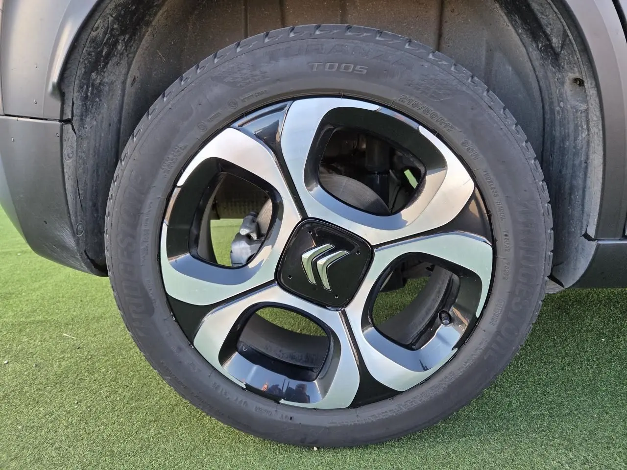 Gros plan sur la jante alliage diamantée 17'' noire et argentée d'un Citroën C3 Aircross gris platinium.