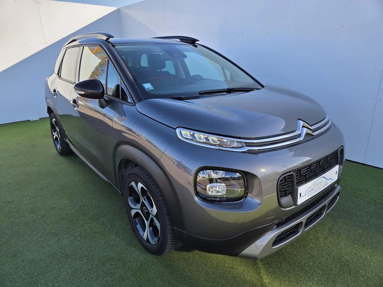 Profil côté gauche d'un Citroën C3 Aircross gris platinium avec toit noir perlé et jantes alliage 17 pouces.