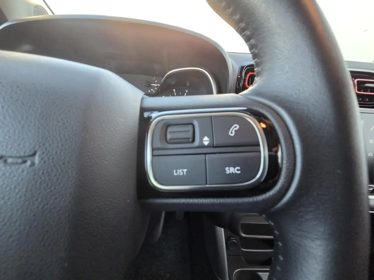 Vue rapprochée du tableau de bord de la Citroën C3 Aircross 2021, affichage numérique et compteurs analogiques noirs.