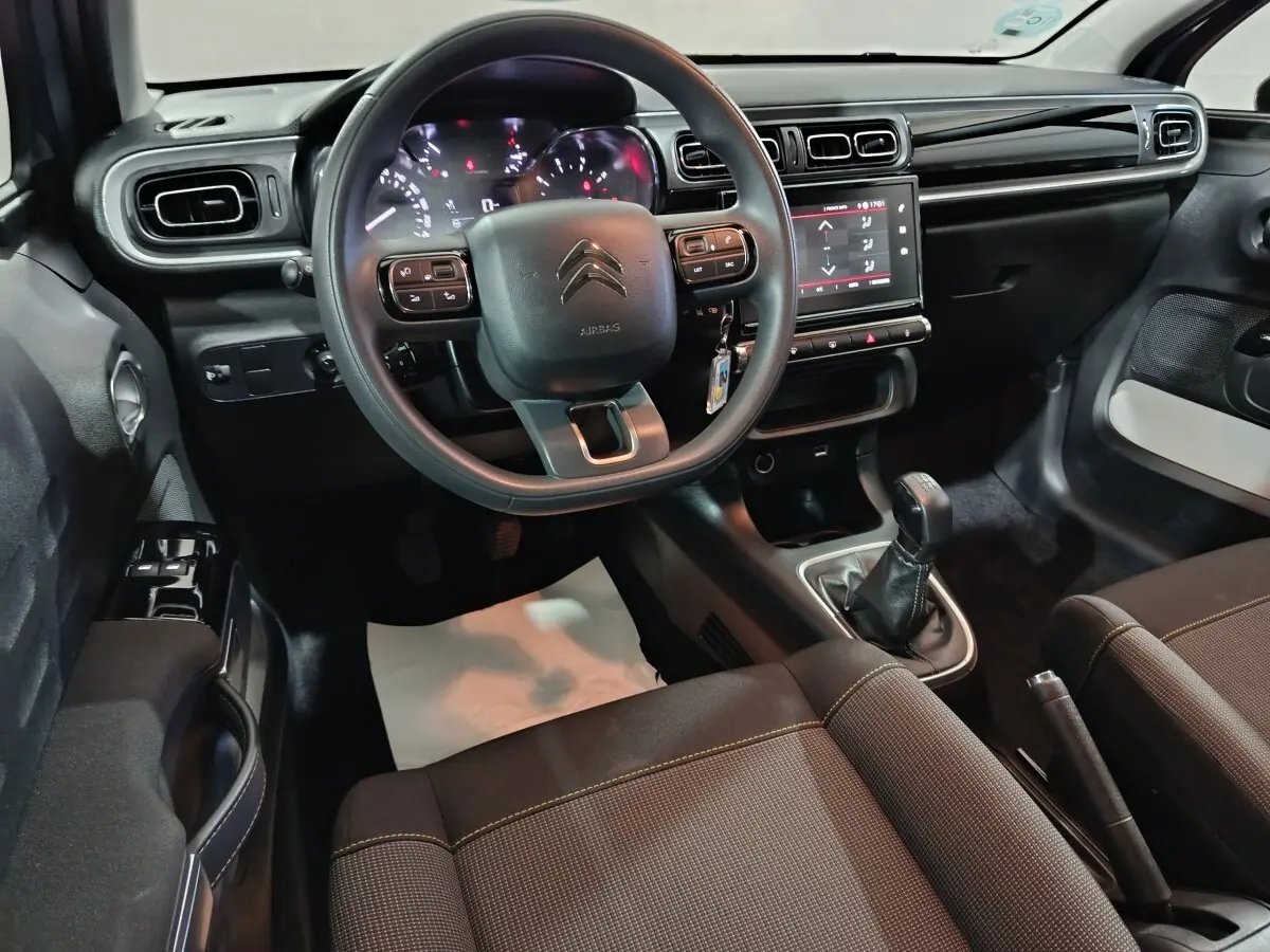 Intérieur de la Citroën C3 PureTech 83 BVM 2024, vue avant centrée sur le volant et la console tactile noire.