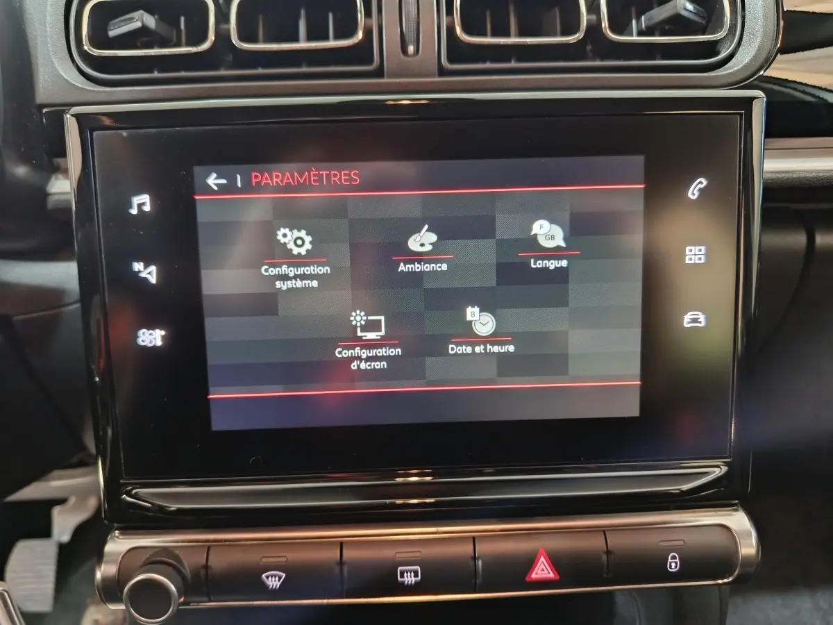 Écran tactile central affichant les paramètres dans l’habitacle sombre d’une Citroën C3 gris foncé 2024 PureTech.
