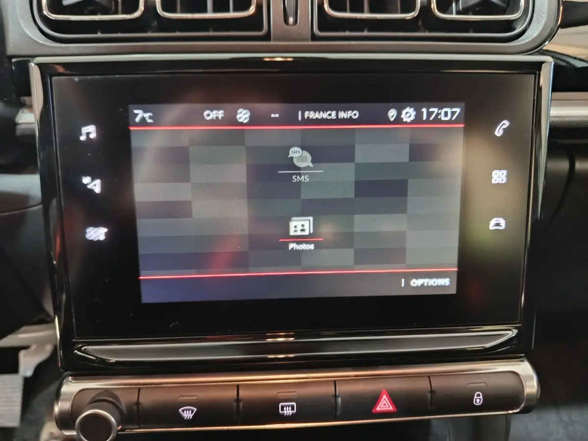 Écran tactile central de la Citroën C3 PureTech 83 BVM MAX 2024 affichant menu SMS et photos, vue rapprochée intérieure.