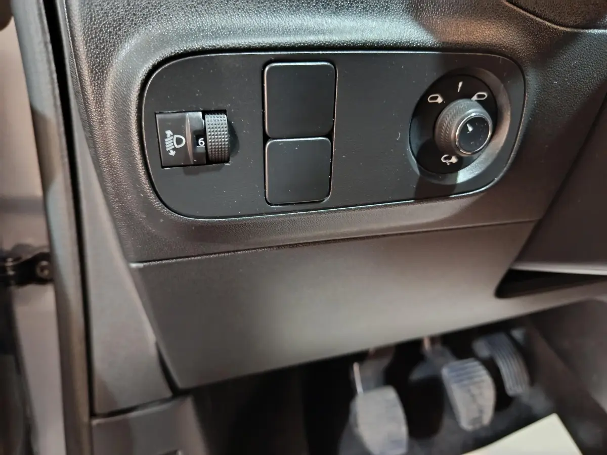 Détail des commandes d'éclairage et réglage des rétroviseurs côté gauche d'une Citroën C3 gris foncé 2024.