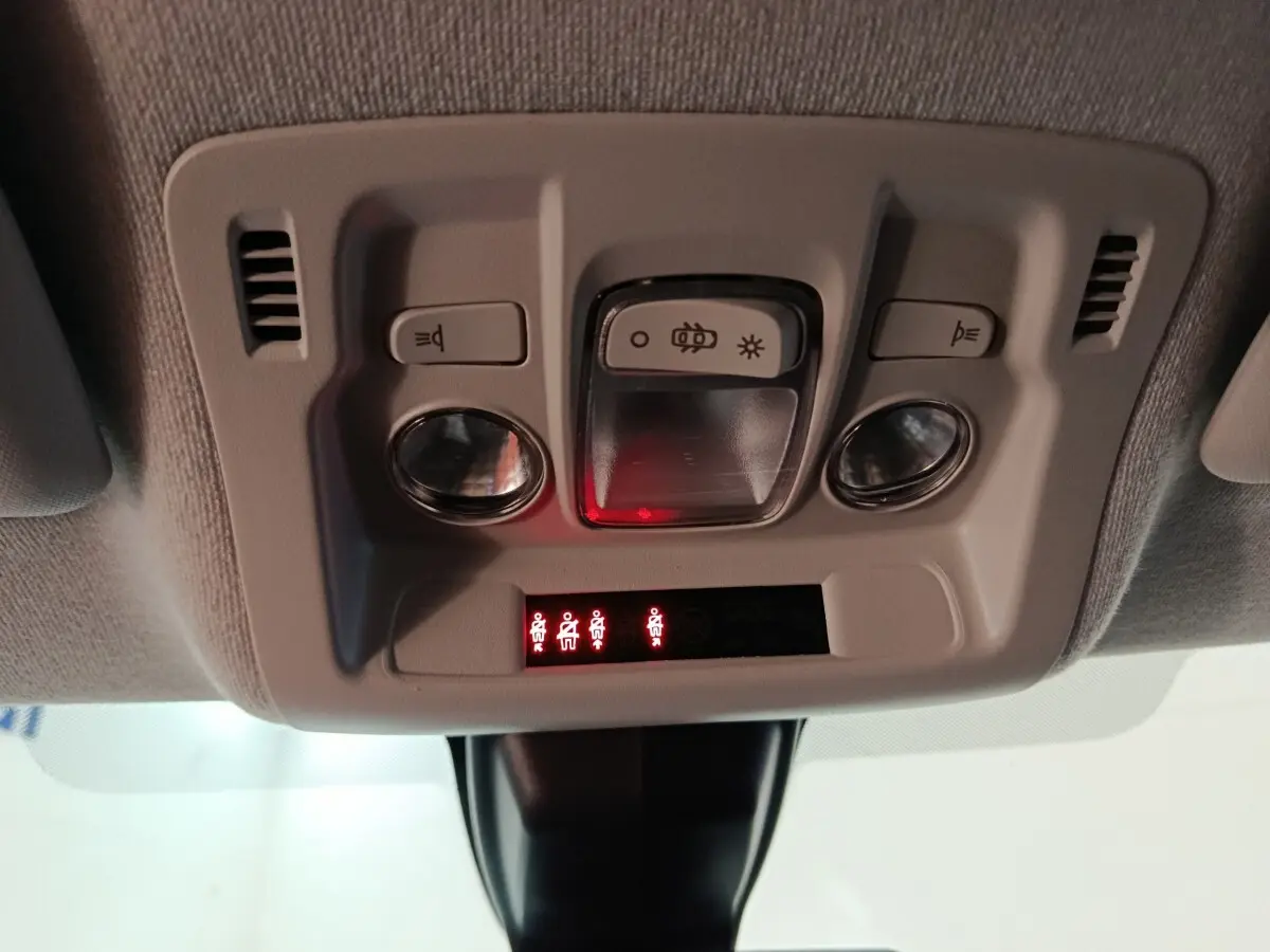 Vue en gros plan du plafonnier gris clair avec commandes d'éclairage et indicateurs de ceinture dans une Citroën C3 2024.