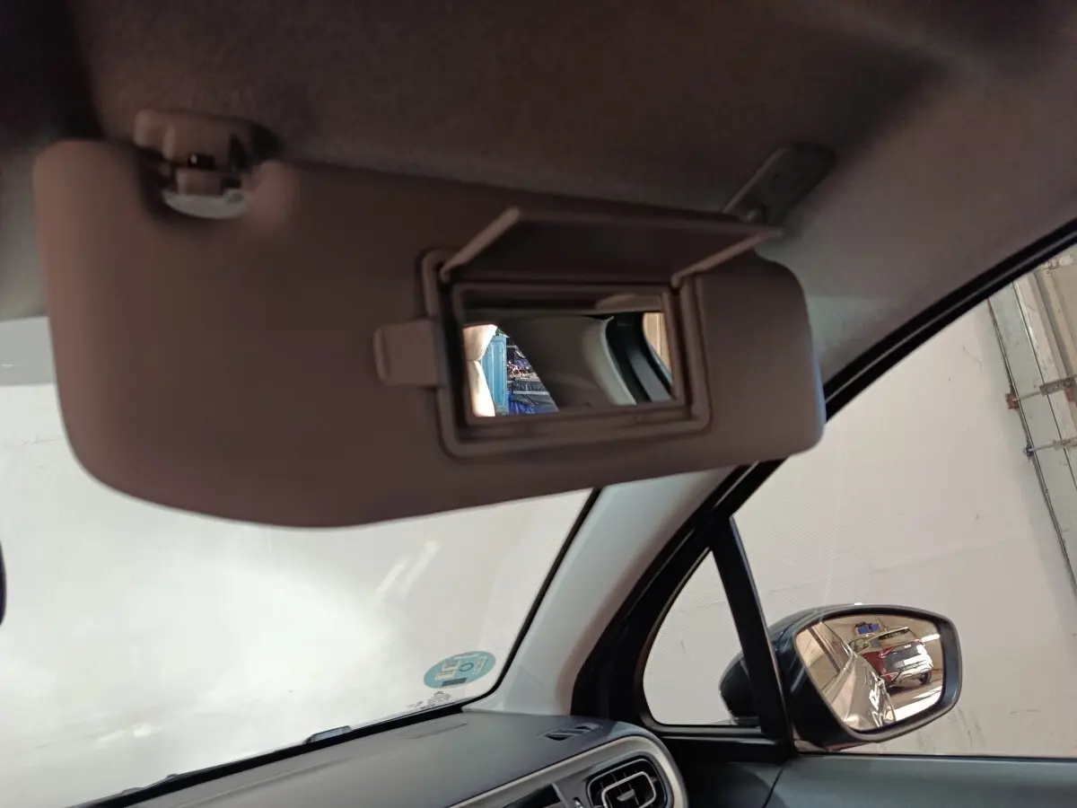 Miroir de courtoisie ouvert sur pare-soleil côté conducteur dans l’habitacle d’une Citroën C3 gris foncé 2024.