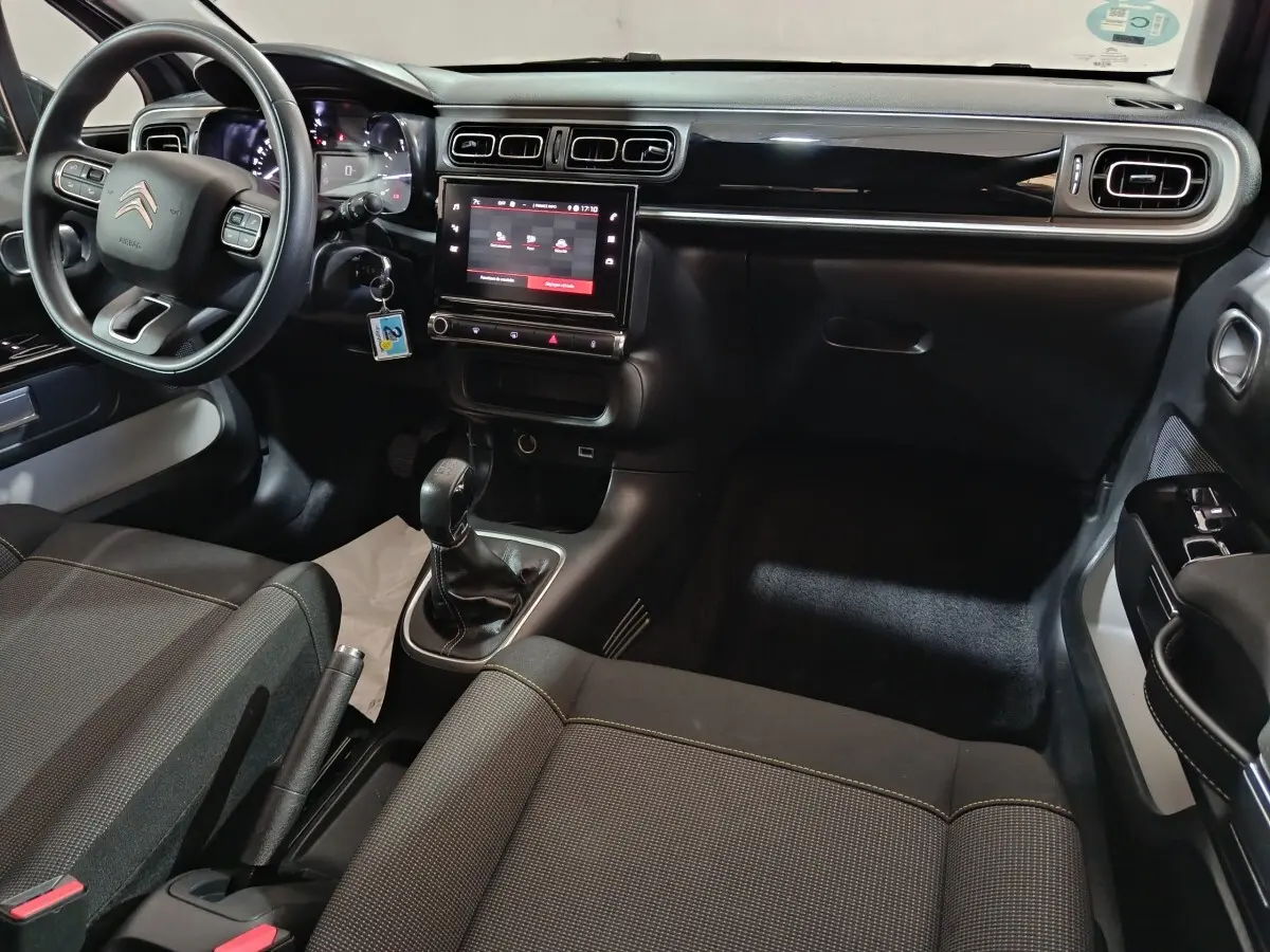 Intérieur avant de la Citroën C3 gris foncé, vue côté conducteur, tableau de bord avec écran tactile central et volant multifonctions.