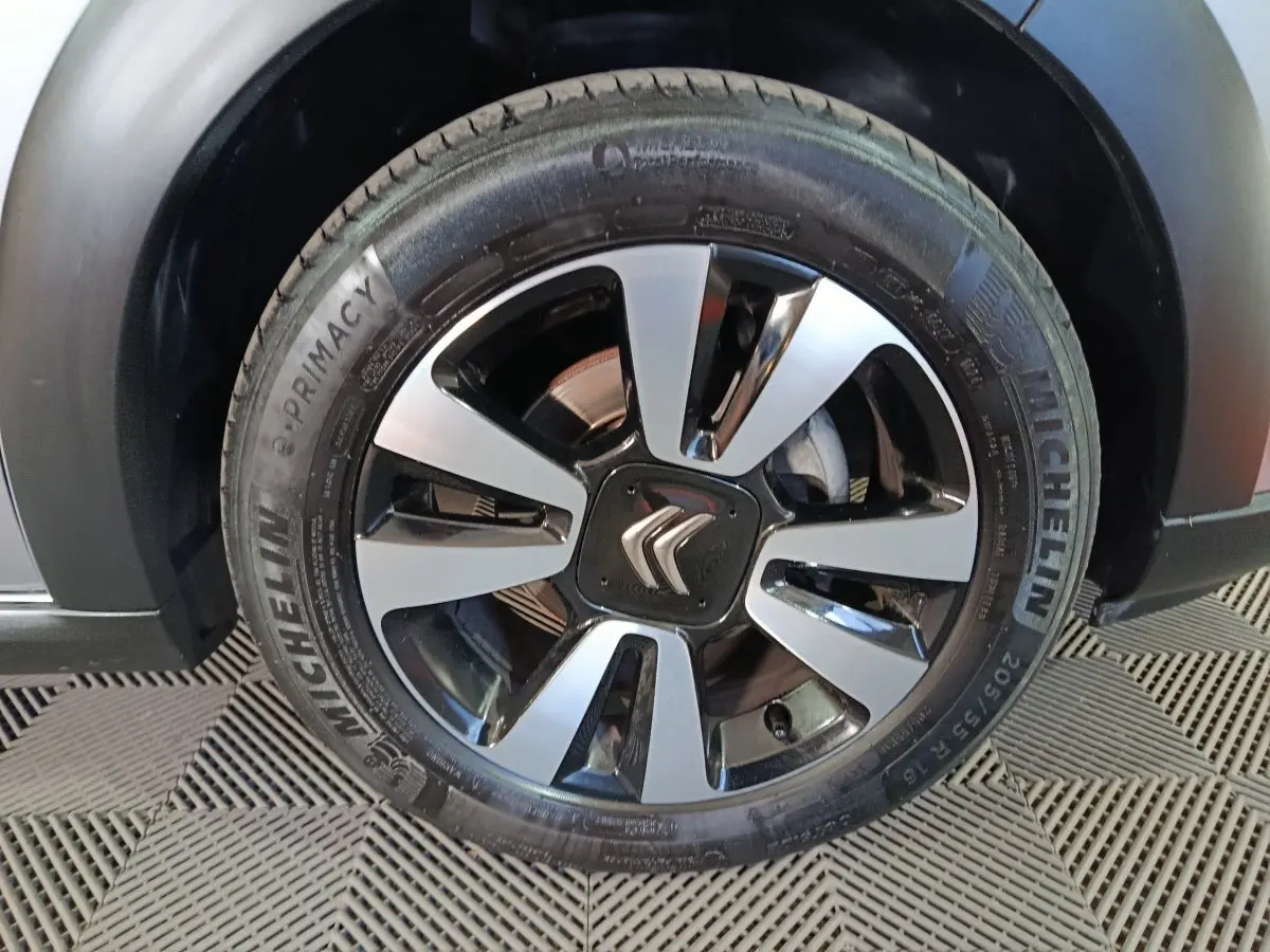 Gros plan sur la roue avant gauche d'une Citroën C3 gris foncé avec jante alliage et pneu Michelin visible