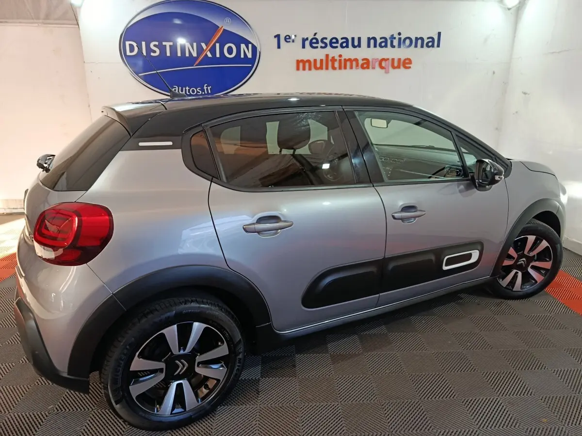 Citroën C3 gris foncé vue de profil côté droit, avec protections latérales noires et jantes stylisées.