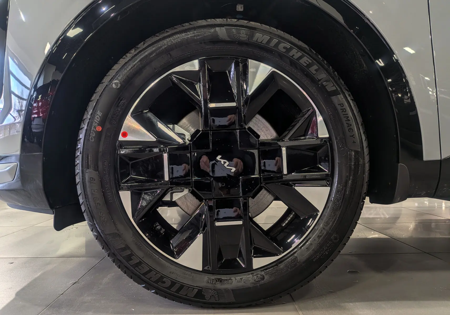 Gros plan sur la jante avant droite noire et argentée du KIA SPORTAGE gris céramique avec toit noir 2025.